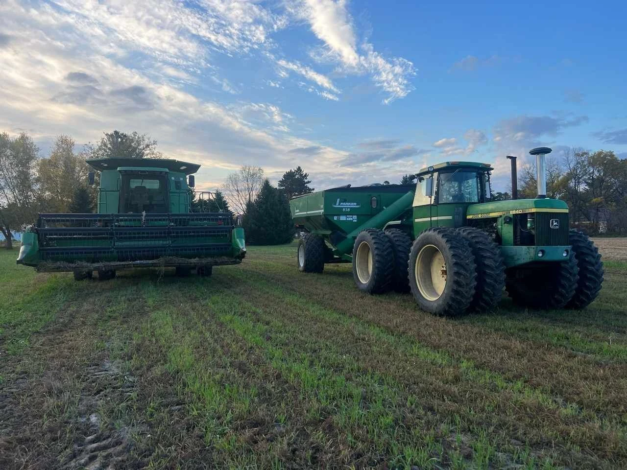 Combine and tractor at dusk