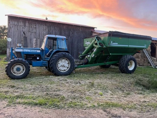 Ford tractor and grain cart at sunset