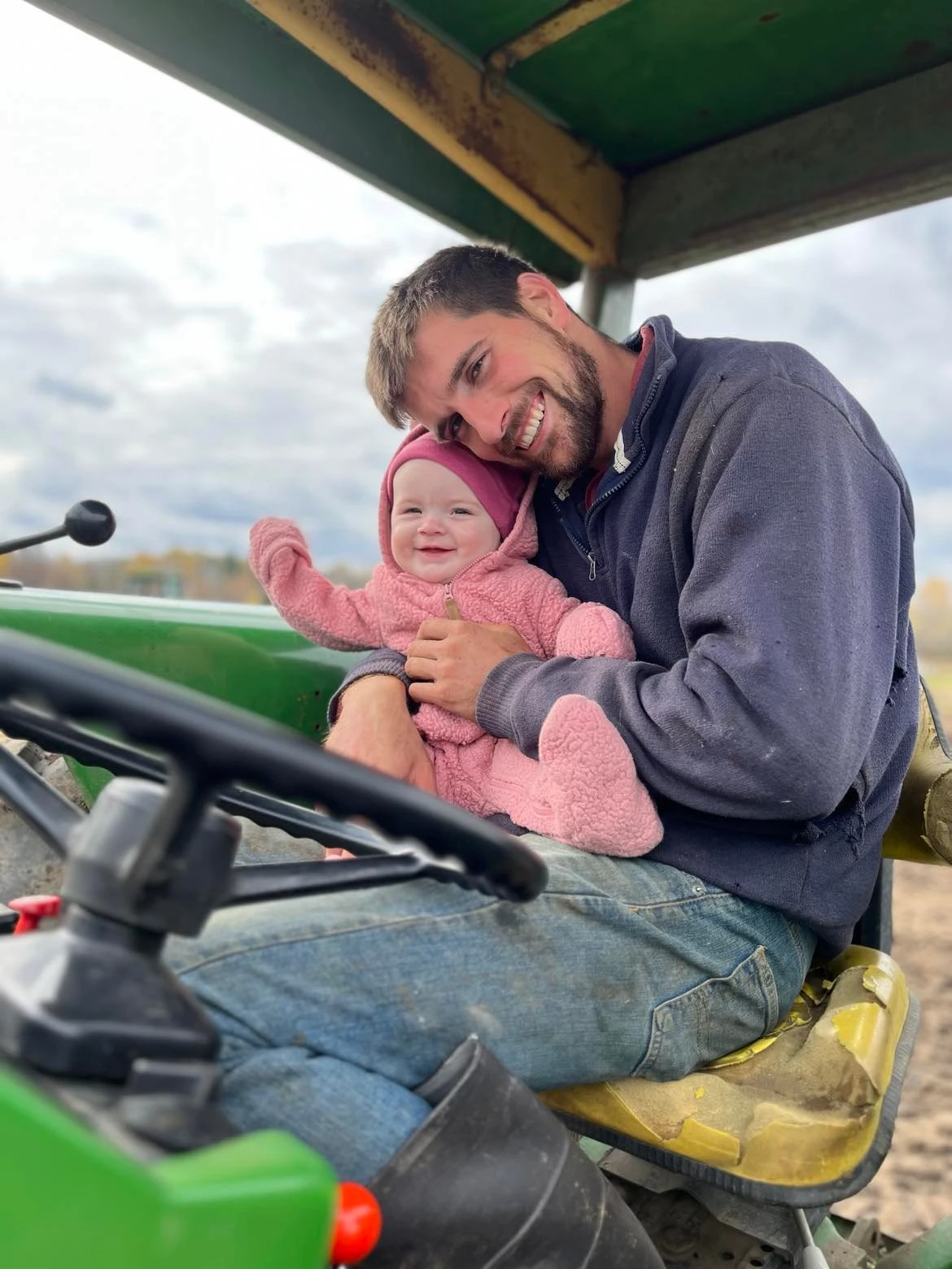 Michael and baby smiling on the tractor